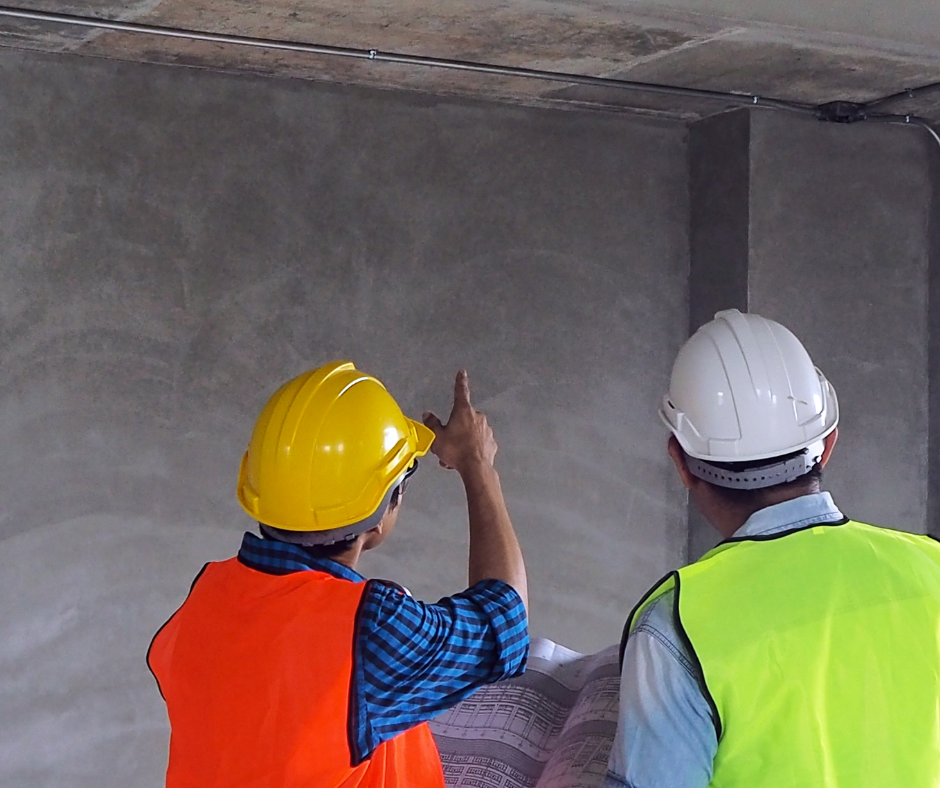 workers looking at a plastered wall